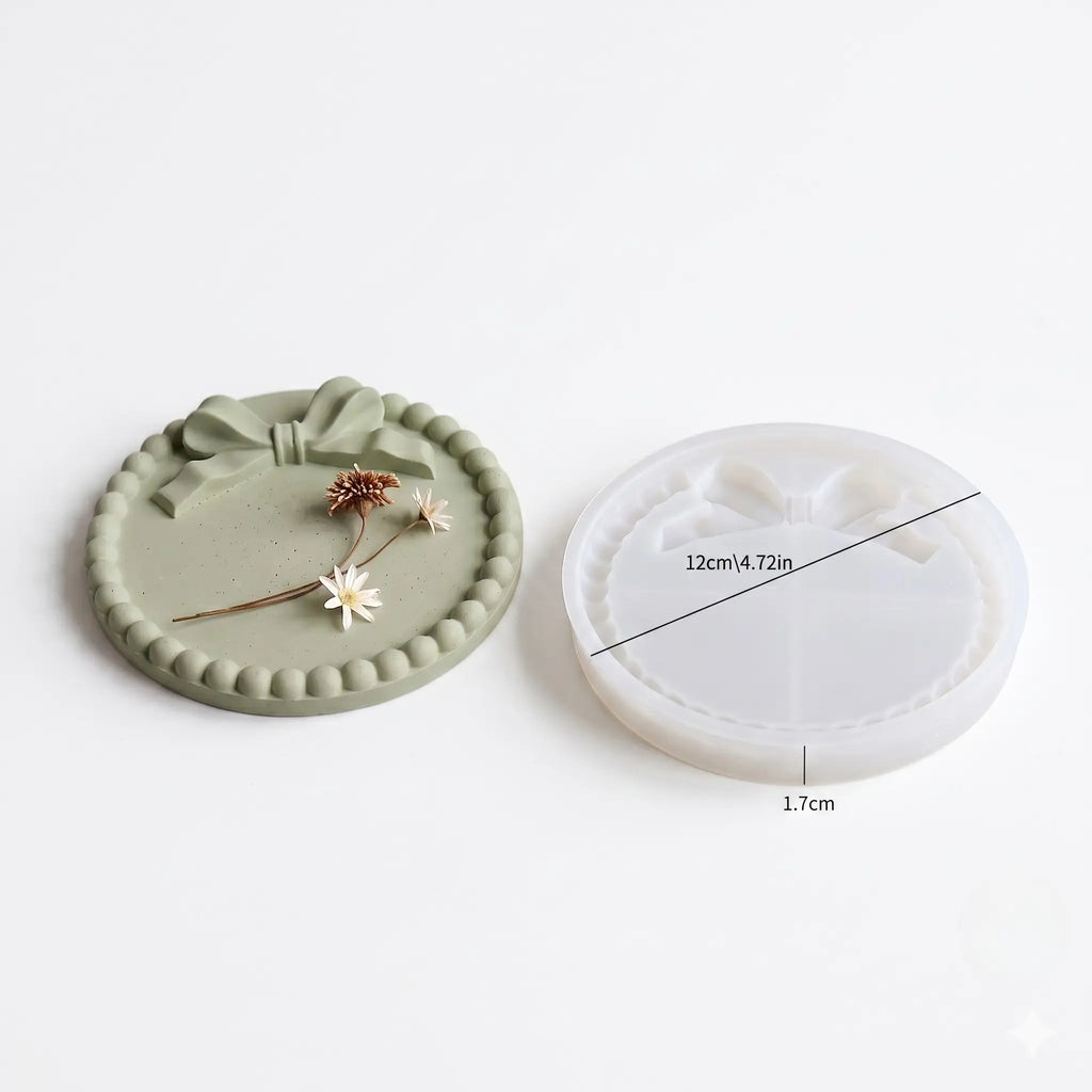 Green ceramic coaster with decorative elements and white silicone mold on a light gray background