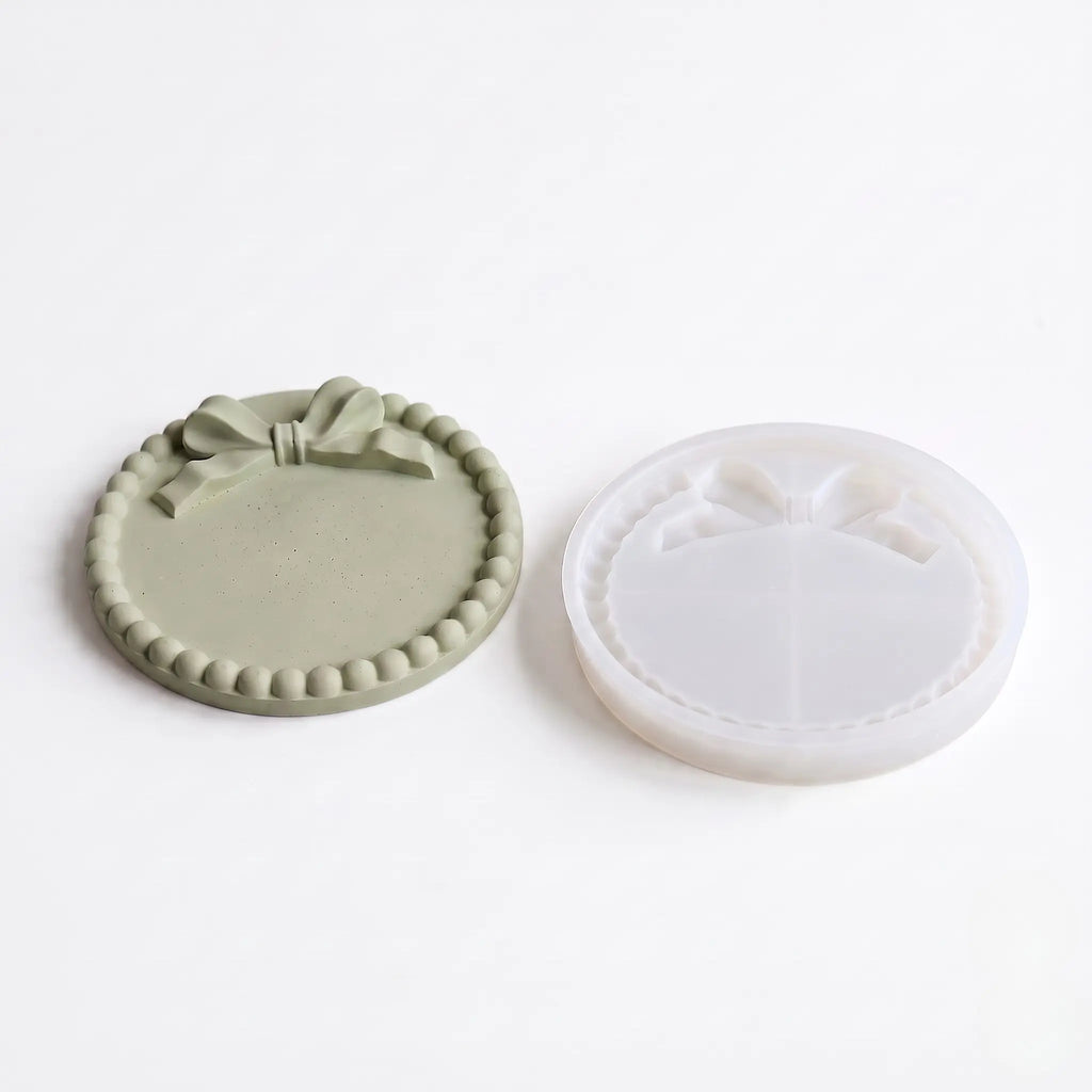Two round silicone molds with decorative edges on a white background
